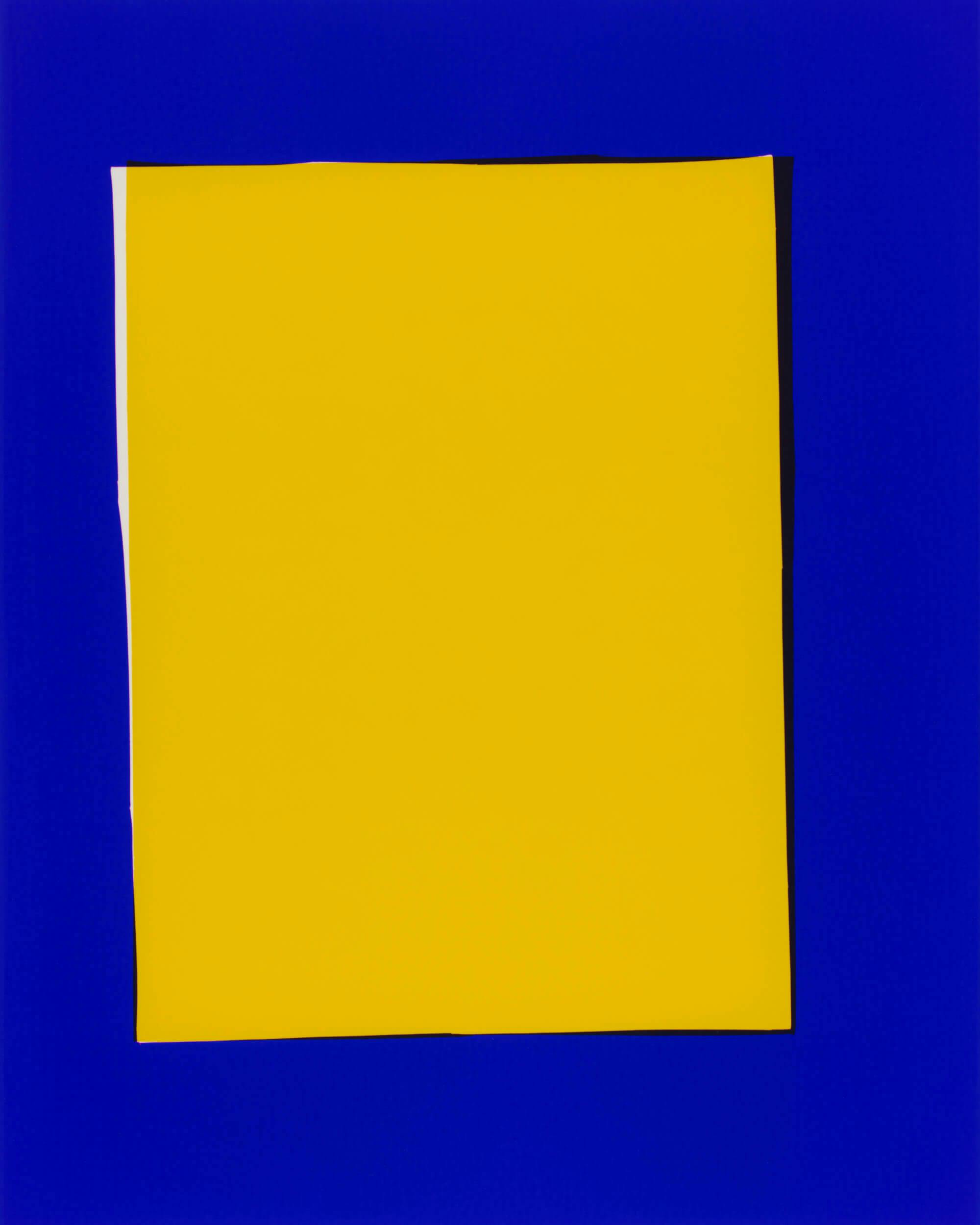 A large, rectangular yellow sheet is centered against a solid blue background. The edges of the yellow sheet are slightly uneven, and there is a visible shadow on the right side.