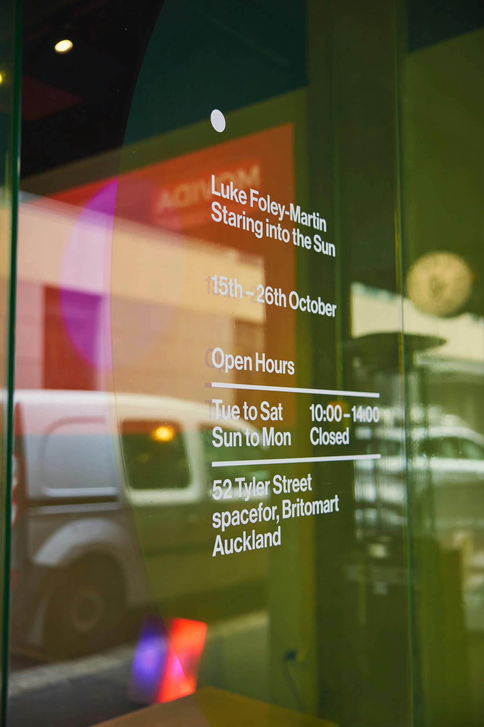 A glass window displays exhibition details: